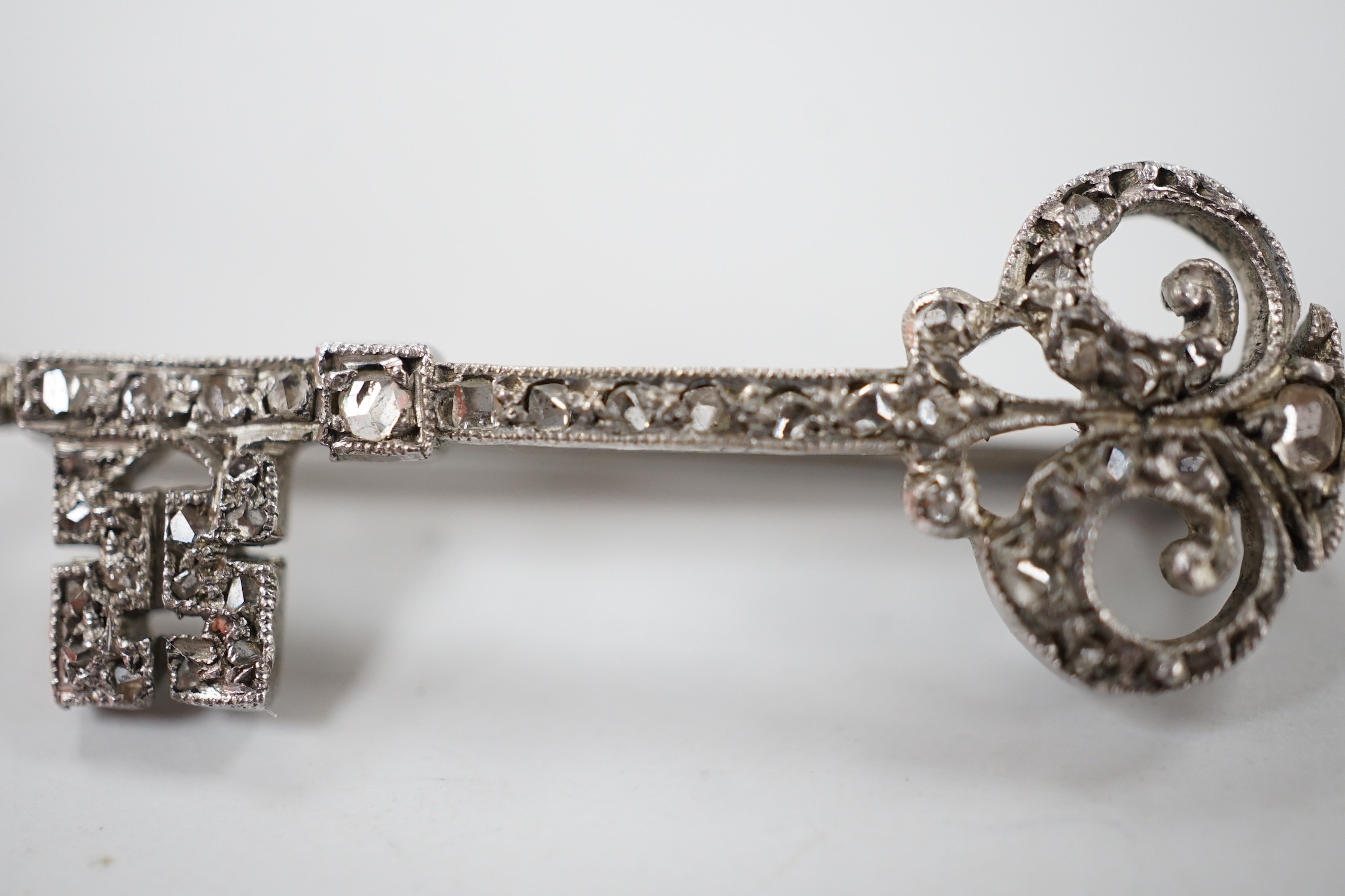 An early 20th century white metal and rose cut diamond set 'key of the door' brooch, 33mm, gross weight 2.1 grams.